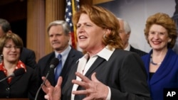 Senate Agriculture Committee member Sen. Heidi Heitkamp, D-N.D., center, joined by fellow committee members, gestures during a news conference on Capitol Hill in Washington, Feb. 4, 2014, after congressional approval of a sweeping five-year farm bill.
