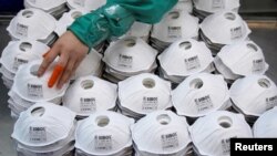 FILE PHOTO: Masks are seen on a production line manufacturing masks at a factory in Shanghai, China January 31, 2020. REUTERS/Aly Song/File Photo