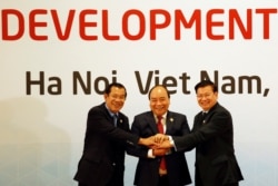 FILE - Cambodia's Prime Minister Hun Sen (L), Vietnam's Prime Minister Nguyen Xuan Phuc (C), and Laos' Prime Minister Thongloun Sisoulith pose for a photo before the 10th Cambodia-Laos-Vietnam summit as part of the Greater Mekong Subregion Summit in Hanoi, Vietnam.
