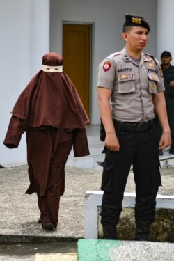 Perempuan pertama yang menjadi eksekutor hukuman cambuk tiba di lokasi pelaksanaan hukuman cambuk untuk seorang terpidana perempuan di Banda Aceh, 10 Desember 2019. (Foto: AFP)