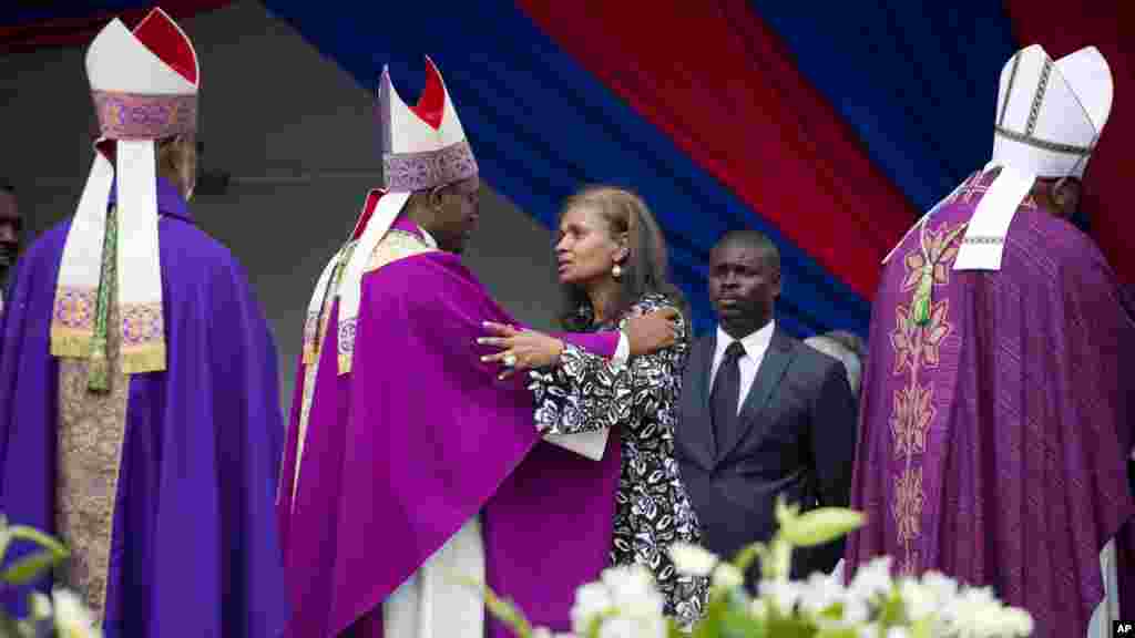 L&#39;évêque catholique Ducange Sylvain présente ses condoléances à l&#39;épouse de l&#39;ancien président René Préval, Elisabeth Debrosse Préval, lors des funérailles du défunt à Port-au-Prince, Haïti, le 11 mars 2017.