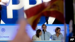 Penjabat Perdana Menteri Spanyol dan kandidat Partai Populer Mariano Rajoy (tengah), merayakan hasil perolehan suara partai dalam pemilu nasional, di Madrid (26/6). (AP/Paul White)