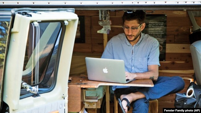 FILE - In this 2018 photo, Danny Fenster works out of his van that he made into a home/office in Detroit, Michigan.