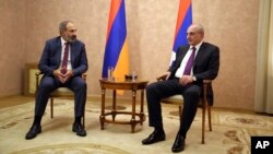 Armenia's Prime Minister Nikol Pashinian, left, and President Bako Sahakyan of the separatist Nagorno-Karabakh region are seen during their meeting in the capital Stepanakert, May 9, 2018. Nagorno-Karabakh, part of Azerbaijan has been under the control of local ethnic Armenian forces and the Armenian military since a war ended in 1994 with no resolution of the region's status.