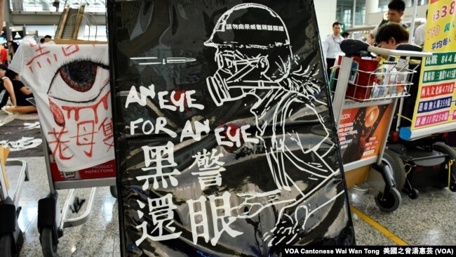  8月14日香港國際機場反送中集會以"黑警還眼"為主題， 抗議警察懷疑在8月11日的尖沙咀清場行動中，近距離 向一名26歲女急救員發射，重創她的右眼球可能導致 永久失明，呼籲國際社會關注警方使用過度武力 （攝影：美國之音湯惠芸）