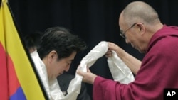 Pemimpin Spiritual Tibet, Dalai Lama (kanan) mengalungkan selendang putih khas Tibet untuk pemimpin partai Demokratik Liberal Jepang, Shinzo Abe di Tokyo (13/11). 