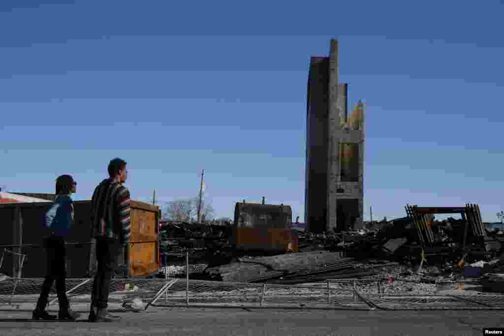 People stand outside the burned community center and apartments across the street from the Southern Baptist Church in Baltimore, Maryland April 28, 2015.