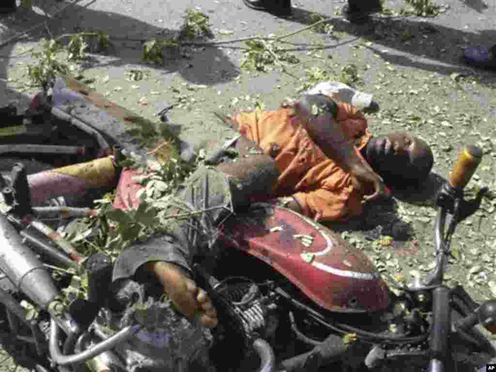 A body of a victim of a suicide bomber lays on the street in Jalingo, Nigeria. Monday, April. 30, 2012 . A motorcycle-riding suicide bomber drove into a convoy carrying a top police official in northeast Nigeria on Monday, detonating his explosives and k