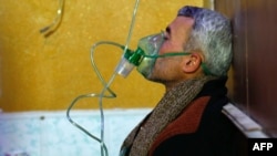 A Syrian man wears an oxygen mask at a makeshift hospital following a reported gas attack on the rebel-held besieged town of Douma in the eastern Ghouta region on the outskirts of the capital Damascus, Jan. 22, 2018. 