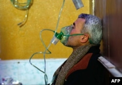A Syrian man wears an oxygen mask at a makeshift hospital following a reported gas attack on the rebel-held besieged town of Douma in the eastern Ghouta region on the outskirts of the capital Damascus, Jan. 22, 2018.