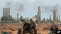 FILE - Anti-government rebels take their position in front the refinery oil complex, in eastern Libya, March 10, 2011.