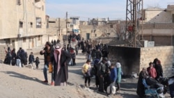 Syrians flee their homes in the Ghwayran neighborhood in the northern city of Hasakeh, Jan. 22, 2022, on the third day of fighting between the Islamic State (IS) group and Kurdish forces in Syria after IS attacked a prison housing jihadists in the area.
