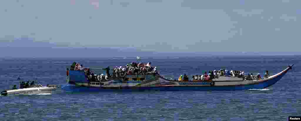 A police patrol boat escorts villagers after they were evacuated from their homes due to fighting between government soldiers and Muslim rebels, near Zamboanga, Philippines, Sept. 17, 2013.