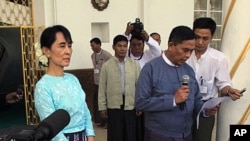 Burma's Labor Minister, Aung Kyi, right, reads out a statement after meeting with democracy leader Aung San Suu Kyi, left, during a press conference in Yangon, Burma, October 30, 2011.