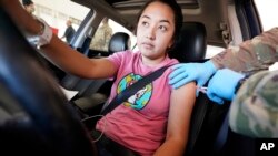 Ivonne Fuentes, sentada en su automóvil, recibe su segunda dosis de la vacuna Pfizer COVID-19 en la unidad de Servicios Humanos y de Salud del Condado de Dallas en Mesquite, Texas, el martes 30 de noviembre de 2021. Archivo.