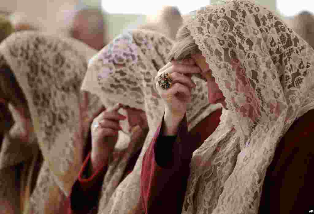 O coro feminino sírio da Igreja Ortodoxa de Santo Afrão, reza durante a missa de Natal em Amã, Jordânia. As famílias cristãs ortodoxas sírias e iraquianas assistem à missa de Natal e rezam pela paz nos seus países.