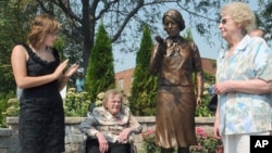Madeline Piller (L), who started the interest in the 'Radium Girls' five years ago - and whose father created the statue - and two original workers from the factory, Pauline 'Toots' Fuller (C) and June Menne (R), after the statue is unveiled, September 2,