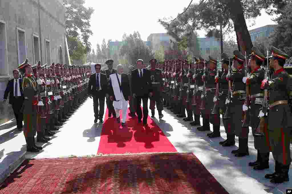 Afghanistan's president Ashraf Ghani Ahmadzai and Britain's Prime Minister David Cameron inspect the guard of honor at the presidential palace in Kabul, Afghanistan, Oct. 3, 2014.