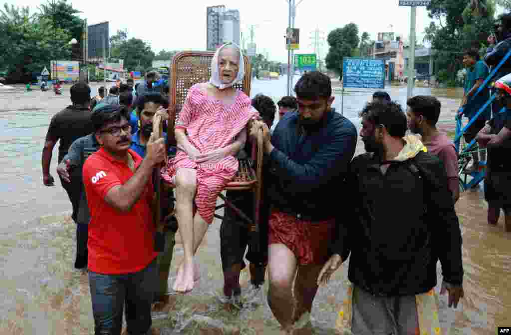 Indian volunteers and rescue personal evacuate local residents in a residential area in Ernakulam district, in the Indian state of Kerala. 