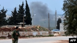 A picture taken on Feb. 20, 2018, shows a Kurdish fighter evacuating following a Turkish artillery bombardment near the Afrin crossing in the northern Syrian region, after Syrian pro-government forces entered the region.