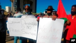 FILE - People hold banners as they protest the deal with Germany over the former colonial power's "genocide', in Windhoek, Namibia, May 28, 2021. Now, a better deal with Berlin is sought.
