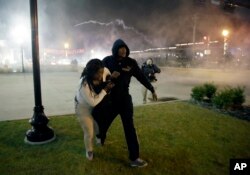 Polisin göz yaşartıcı gazla müdahalesinin ardından kaçmaya çalışan göstericiler