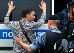 Police officer detains a supporter of Russian investigative journalist Ivan Golunov during a march in Moscow, June 12, 2019.