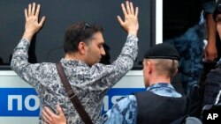 Police officer detains a supporter of Russian investigative journalist Ivan Golunov during a march in Moscow, Russia, Wednesday, June 12, 2019.