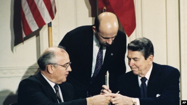 美国前总统里根（右）与前苏联领导人戈尔巴乔夫1987年12月8日签署《中导条约》后交换签字笔（美联社）