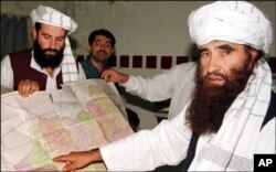 FILE - Sirajuddin Haqqani, far left, and Jalaluddin Haqqani, far right, then Taliban Army Supreme Commander, meet with reporters in Miram Shah, Waziristan on Aug. 22, 1998.