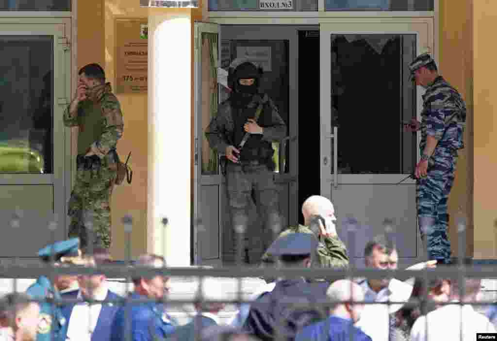 Law enforcement officers stand next to the entrance of School Number 175 after a deadly shooting in Kazan, Russia.&nbsp;At least seven students, one teacher and another worker were fatally shot when a gunman opened fire at an elementary school.