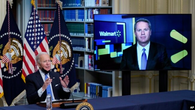 President Joe Biden speaks during a meeting with business leaders about the holiday shopping season, in the library of the Eisenhower Executive Office Building on the White House campus, Nov. 29, 2021, in Washington, as Doug McMillon, CEO of Walmart, listens.