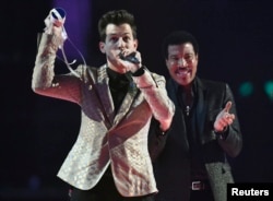 Mark Ronson celebrates with Lionel Richie after receiving the British Single award at the BRIT music awards at the O2 Arena in Greenwich, London, Feb. 25, 2015.