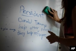 A volunteer teacher erases the board after teaching her Christian Burmese refugees English in Kuala Lumpur, Malaysia, March 11, 2017.