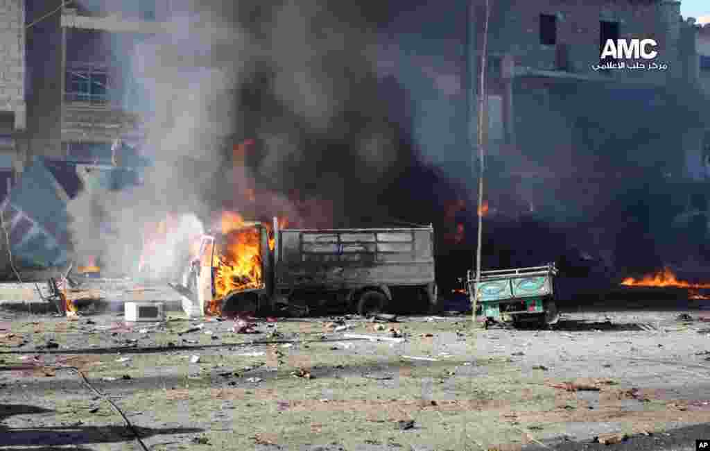 In this citizen journalism image, vehicles burn after a Syrian aircraft pummeled an opposition neighborhood in Aleppo, Syria, Dec. 22, 2013.