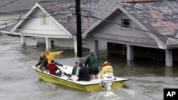 St. Berard Parish deputy sheriff Jerry Reyes uses his boat to rescue residents after Hurricane Katrina hit the area causing flooding in their New Orleans neighborhood, Monday Morning, Aug. 29, 2005.