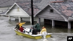 FILE - St. Bernard Parish Deputy Sheriff Jerry Reyes uses his boat to rescue residents after Hurricane Katrina hit the area causing flooding in their New Orleans neighborhood, Aug. 29, 2005.