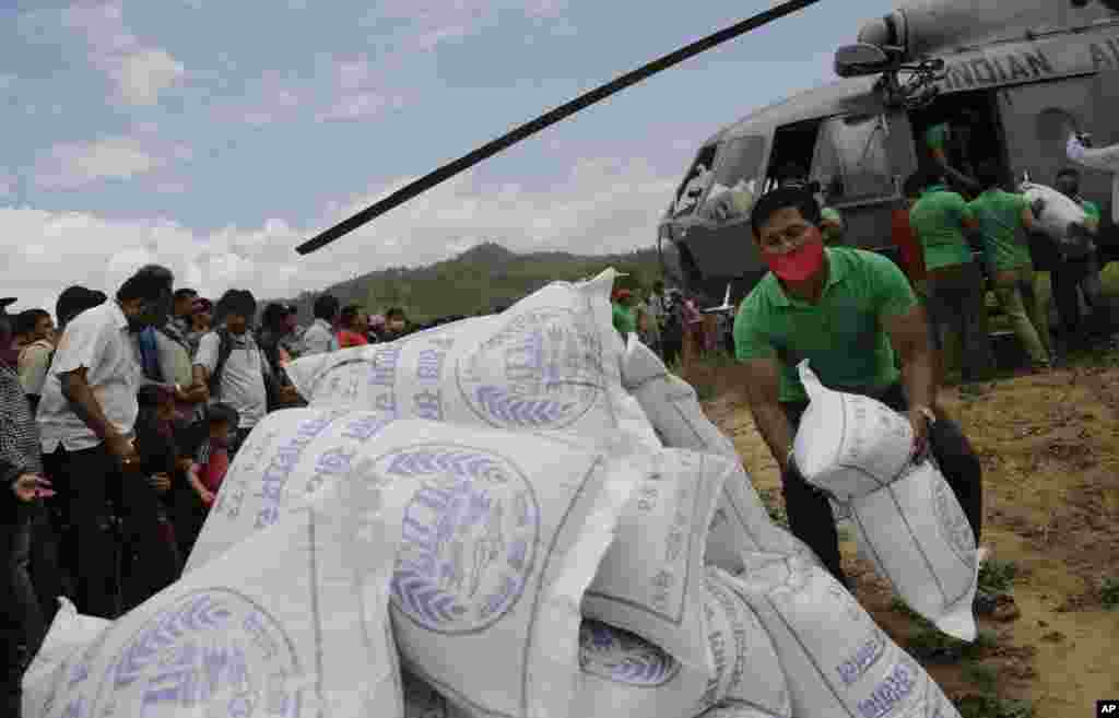 Nepalese volunteers unload relief supplies from an Indian air force helicopter for victims of Saturday’s earthquake at Trishuli Bazar in Nepal.
