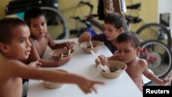 FILE - Honduran children have meals at the Todo por ellos (All for Them) immigrant shelter in Tapachula, Chiapas, in southern Mexico, June 26, 2014.