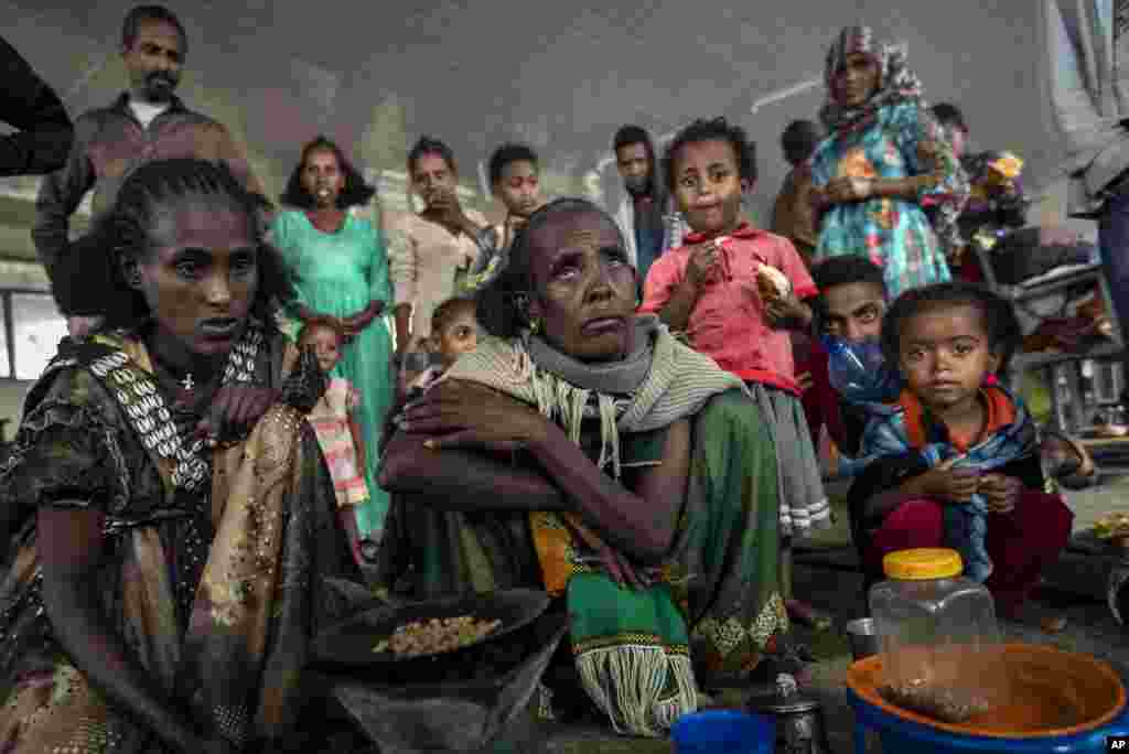 Displaced Tigrayan women who fled from the town of Samre, roast coffee beans over a wood stove at the Hadnet General Secondary School which has become a makeshift home to thousands displaced by the conflict, in Mekele, in the Tigray region of northern Ethiopia.