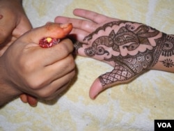 Putting henna on brides and guests is one of the elaborate ceremonies at Indian weddings. (A. Pasricha/VOA)