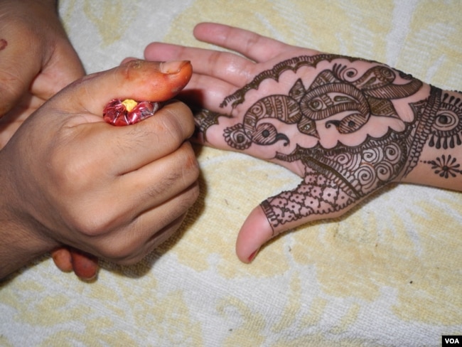 Putting henna on brides and guests is one of the elaborate ceremonies at Indian weddings. (A. Pasricha/VOA)