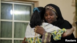 Keluarga korban tragedi haji berpelukan saat melayat di Kaduna, Nigeria (26/9). (Reuters/Afolabi Sotunde)