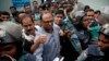 FILE - Bangladeshi newspaper editor Mahmudur Rahman, center, is brought to a court following his arrest on various charges in Dhaka, April 11, 2013. Offcials say they'll question him in an alleged conspiracy case involving the prime minister's son.