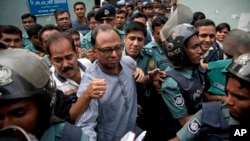FILE - Bangladeshi newspaper editor Mahmudur Rahman, center, is brought to a court following his arrest on various charges in Dhaka, April 11, 2013. Offcials say they'll question him in an alleged conspiracy case involving the prime minister's son.