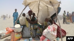 Femmes et enfants évacués des îles du lac Tchad, assis sous une tente de fortune à N'Guigmi, Niger, le 5 mai 2015