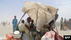 FILE - A handout photo released by the World Food Program shows women and children evacuated from the islands of Lake Chad sitting under a makeshift tent in N'Guigmi, Niger, May 5, 2015. The U.N. Security Council on March 3, 2017, kicked off a visit to spotlight Africa's worst humanitarian crisis as millions face hunger amid the Boko Haram insurgency in Nigeria and the Lake Chad region.