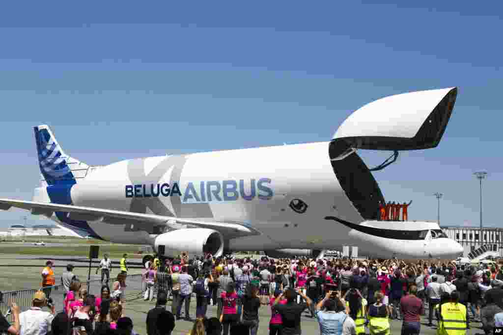 The engineers wave from the deck of the Airbus BelugaXL after successfully completing its first flight at Toulouse-Blagnac airport, in Toulouse, southern France, Thursday, July 19, 2018. The flight will kick off a 10-month flight test certification campaign leading to planned service entry in 2019.