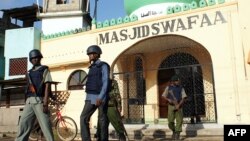 Kenyan police officers stand guard outside the Masjid Swafaa mosque in the district of Kisauni in Kenya's coastal town of Mombasa following a raid, Nov. 19, 2014. 