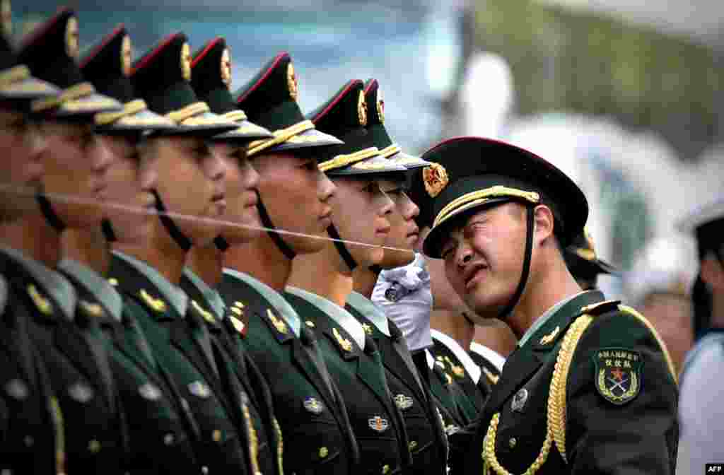 Chinese honor guards prepare for the arrival of Myanmar (also known as Burma) President U Thein Sein and Chinese President Xi Jinping during a welcome ceremony outside the Great Hall of the People in Beijing. A string is set up to ensure members of the guard stand in a straight line. 